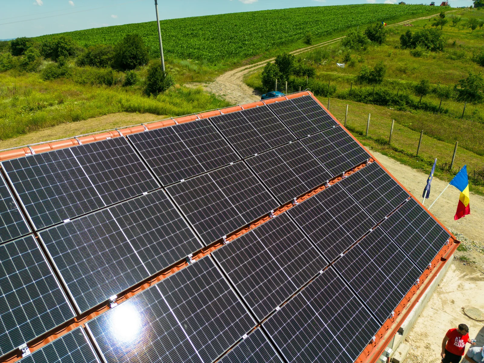 Panouri fotovoltaice montate pe un acoperiș de țiglă, fotografiate de aproape cu drona